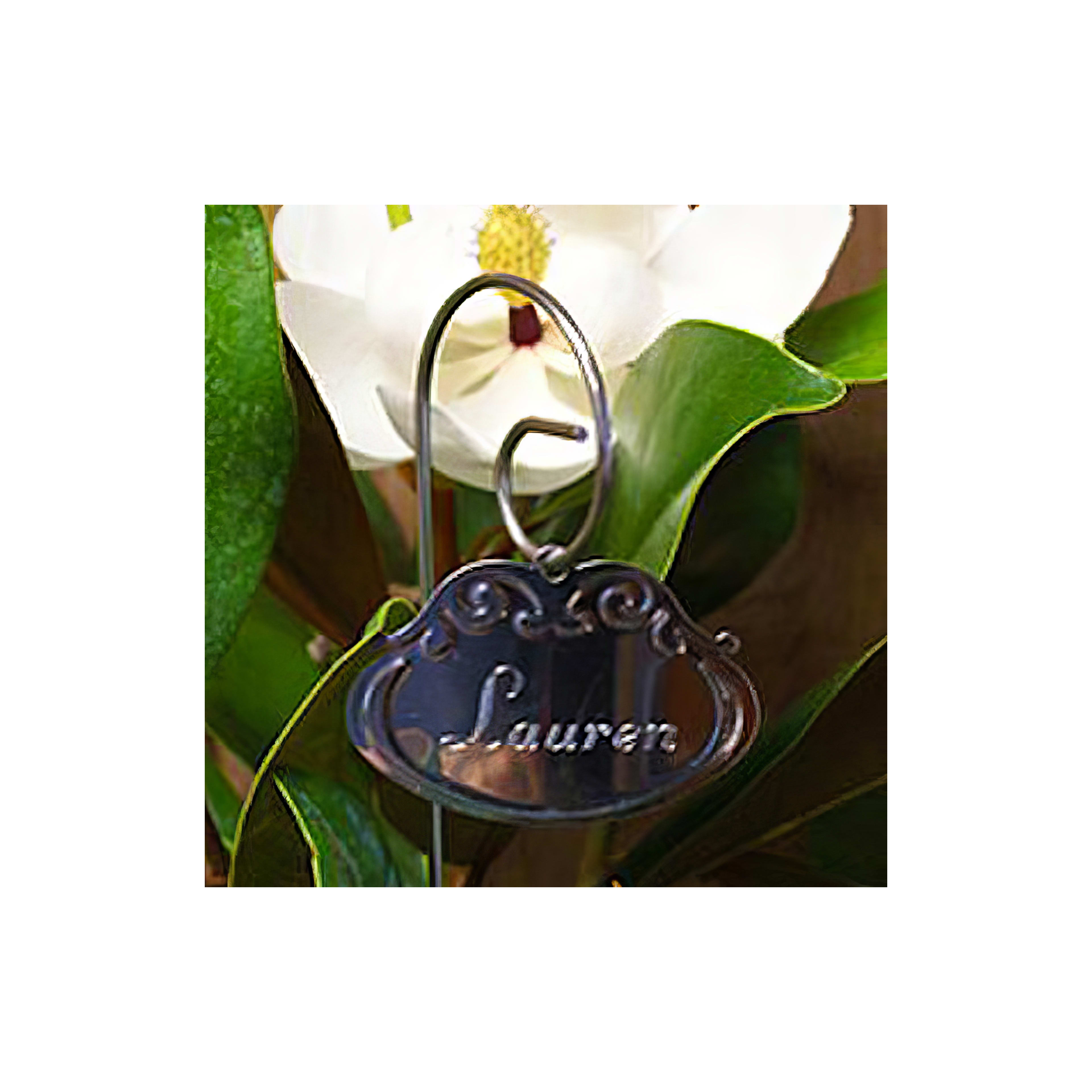 A name tag reading Lauren is prominently displayed among lush green foliage and a white bloom.
