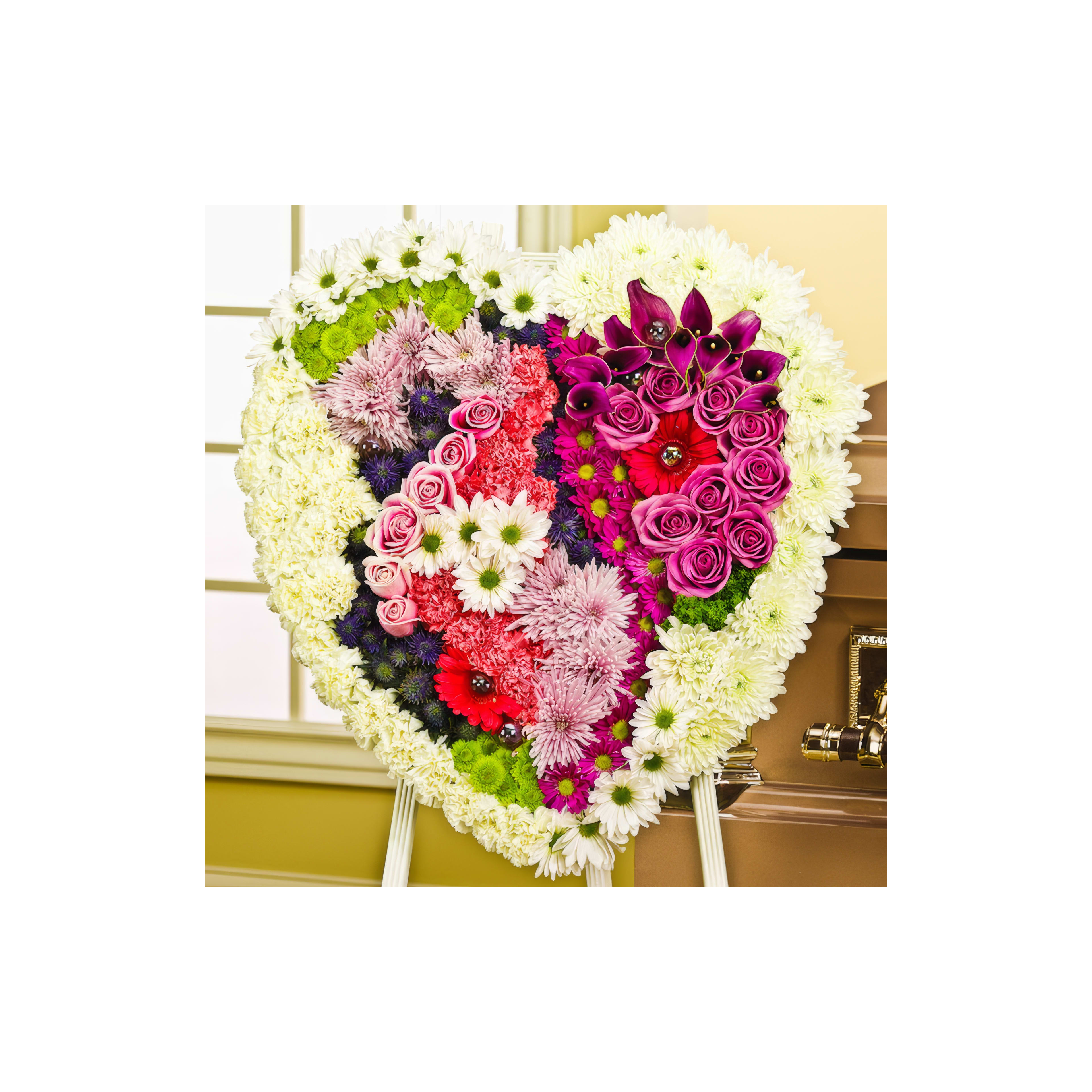 Beautiful heart-shaped display of colorful flowers in varying shades for a celebration.