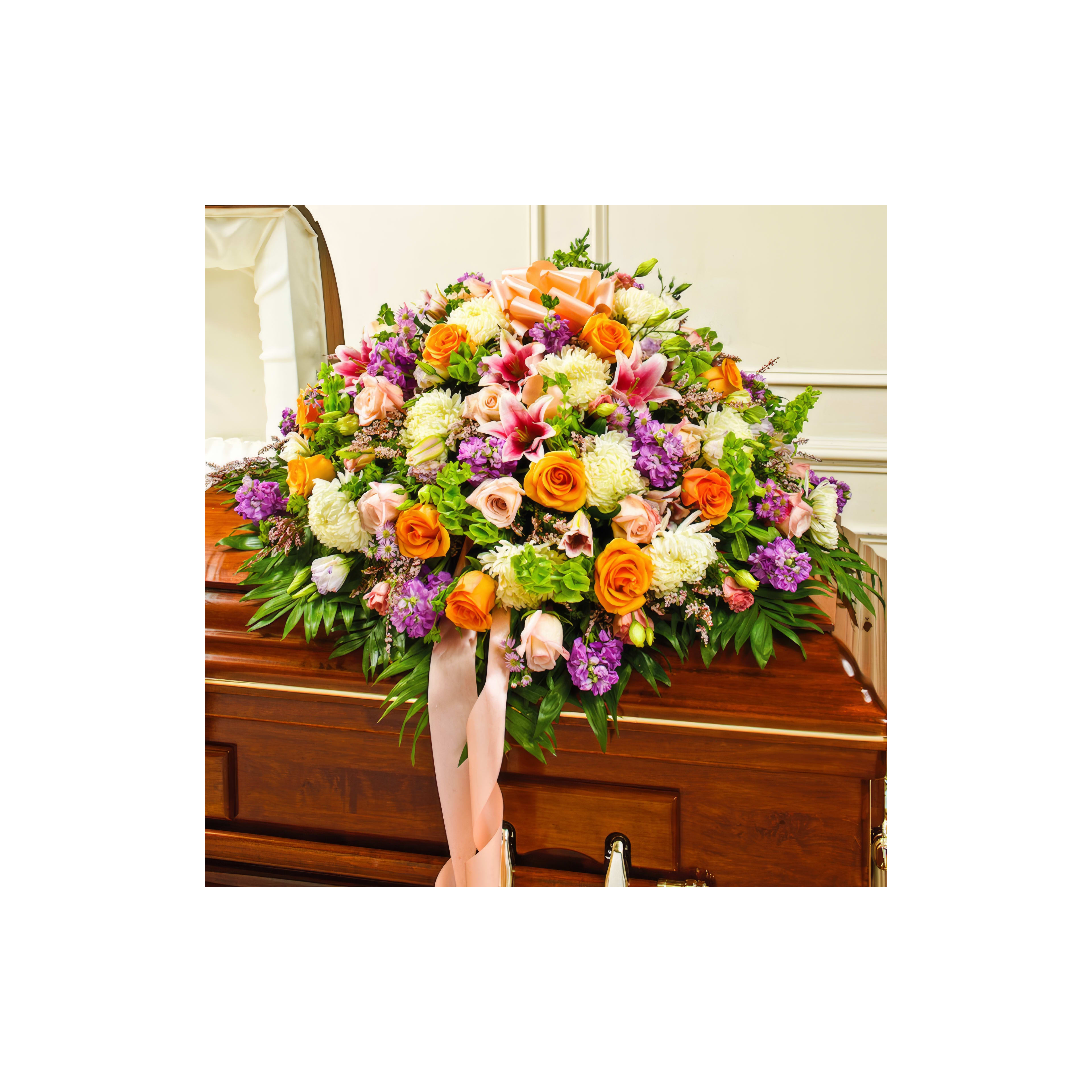 A colorful floral display rests atop a wooden casket, honoring a meaningful farewell.
