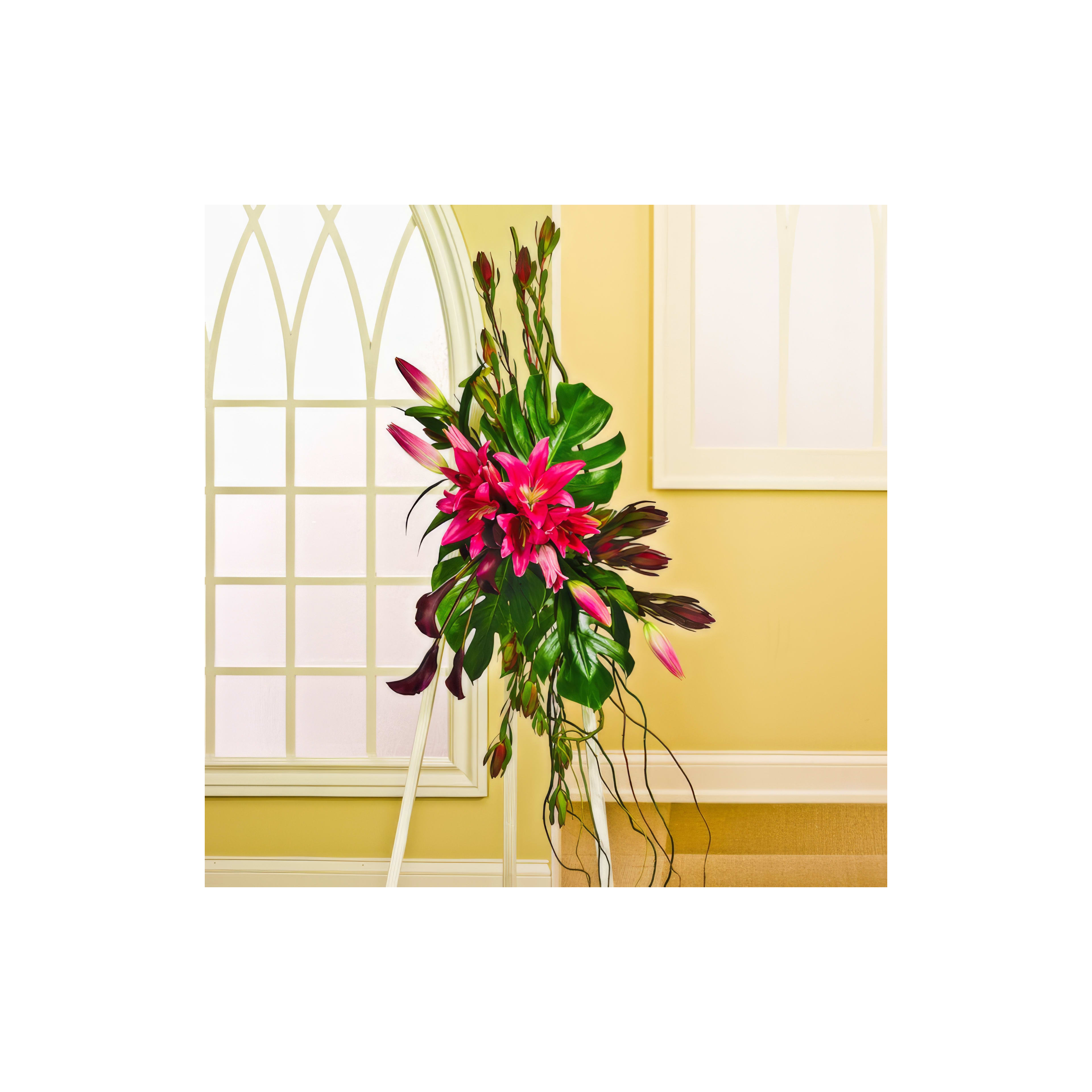 Vibrant pink lilies and lush green leaves create a stunning indoor floral display by the window.