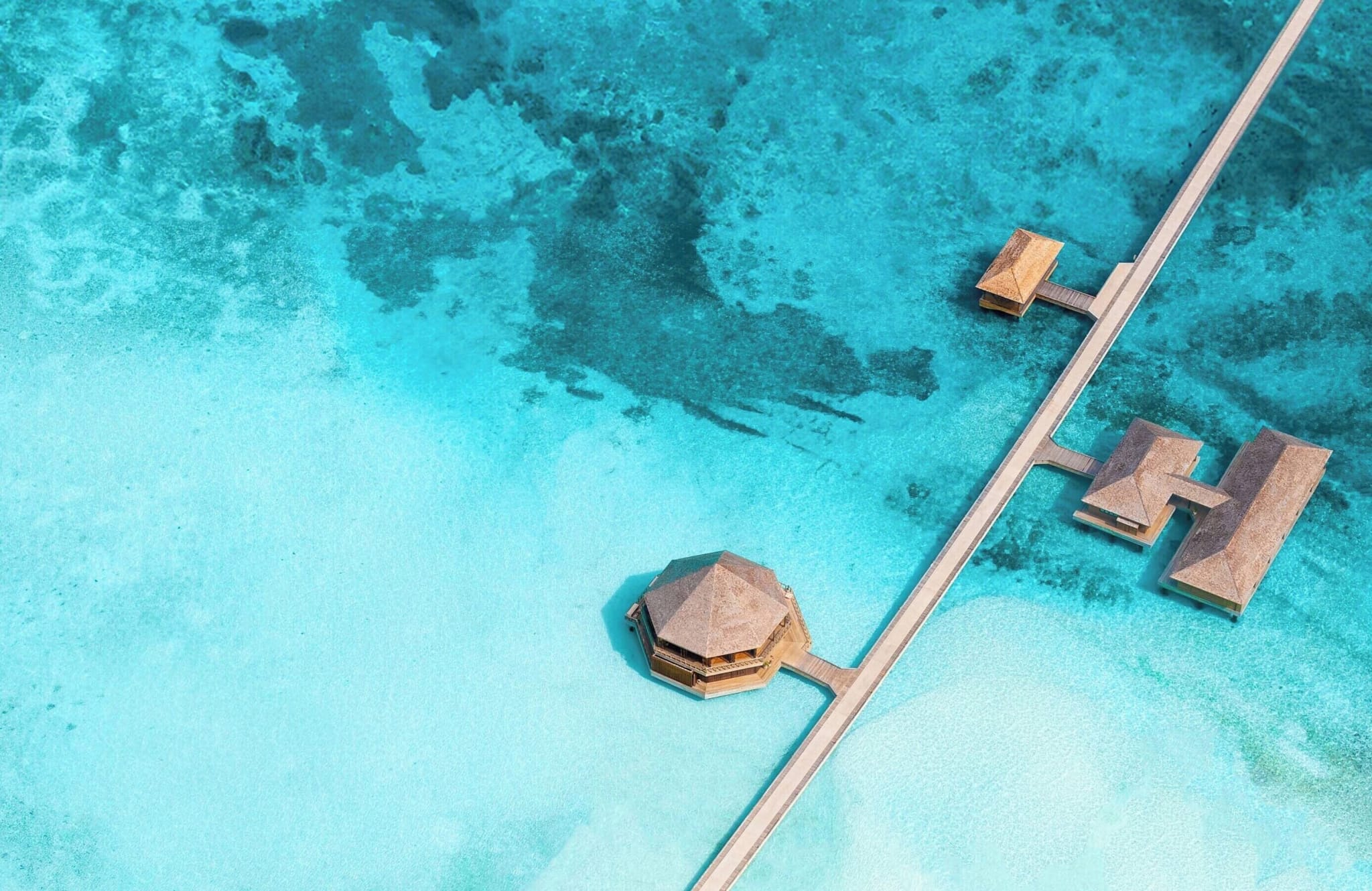 Aerial view of the bridge between Mabin and Dheru at Jawakara Islands, with restaurant pavilions out in the lagoon.