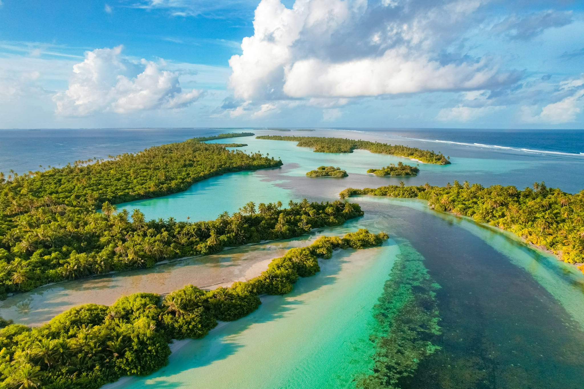 Aerial view of small wooded islands and turquoise lagoons in the Maldives.