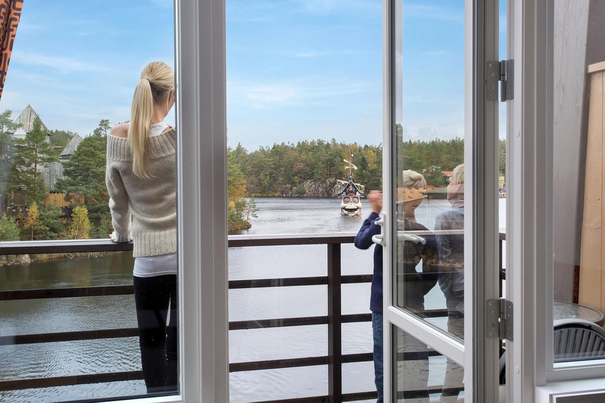 A balcony looking out over forest and water at Dyreparken Safarihotell in Kristiansand