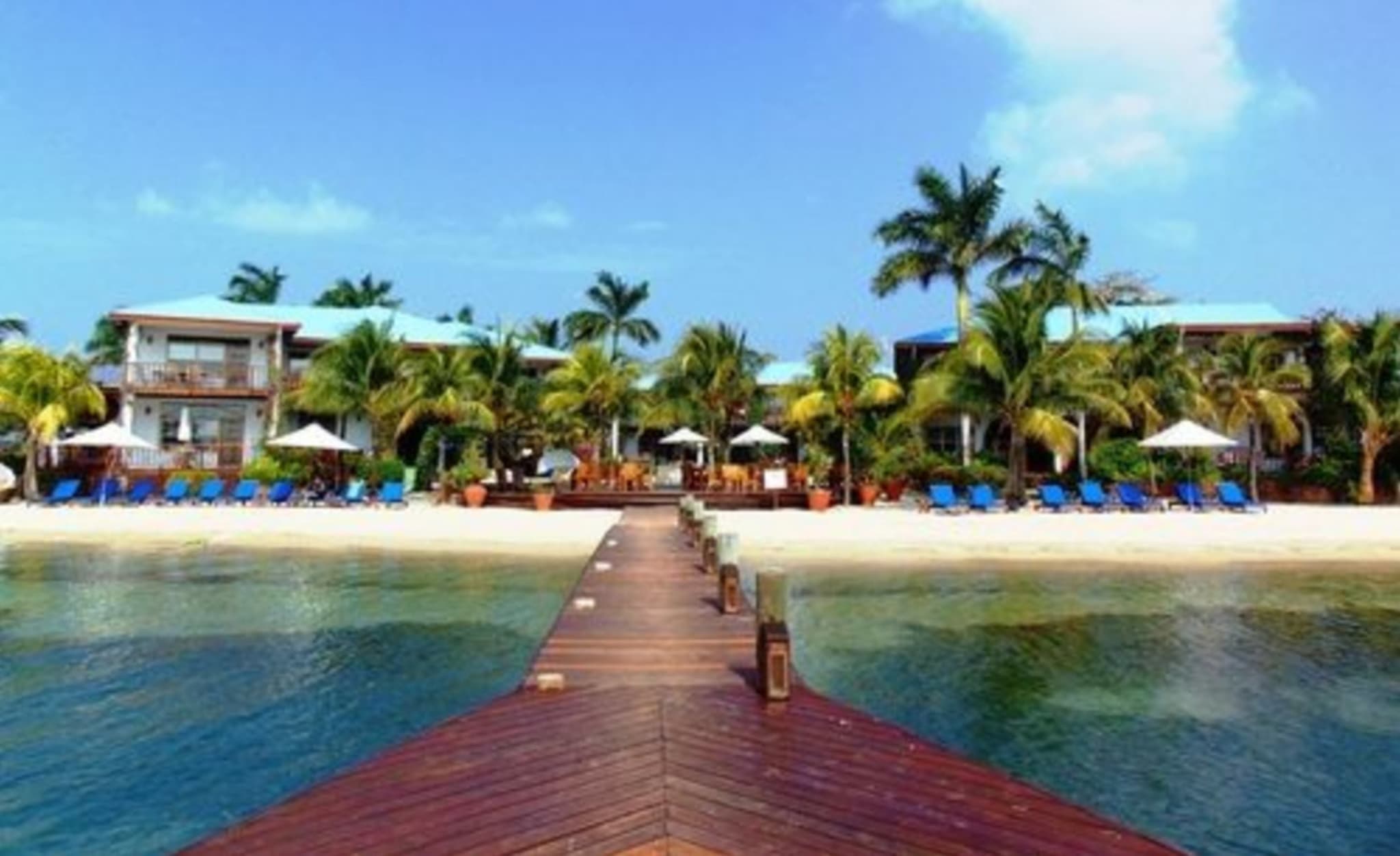 Brygge ut i turkist vann ved Chabil Mar i Placencia i Belize, et utgangspunkt for fluefiske i tropene