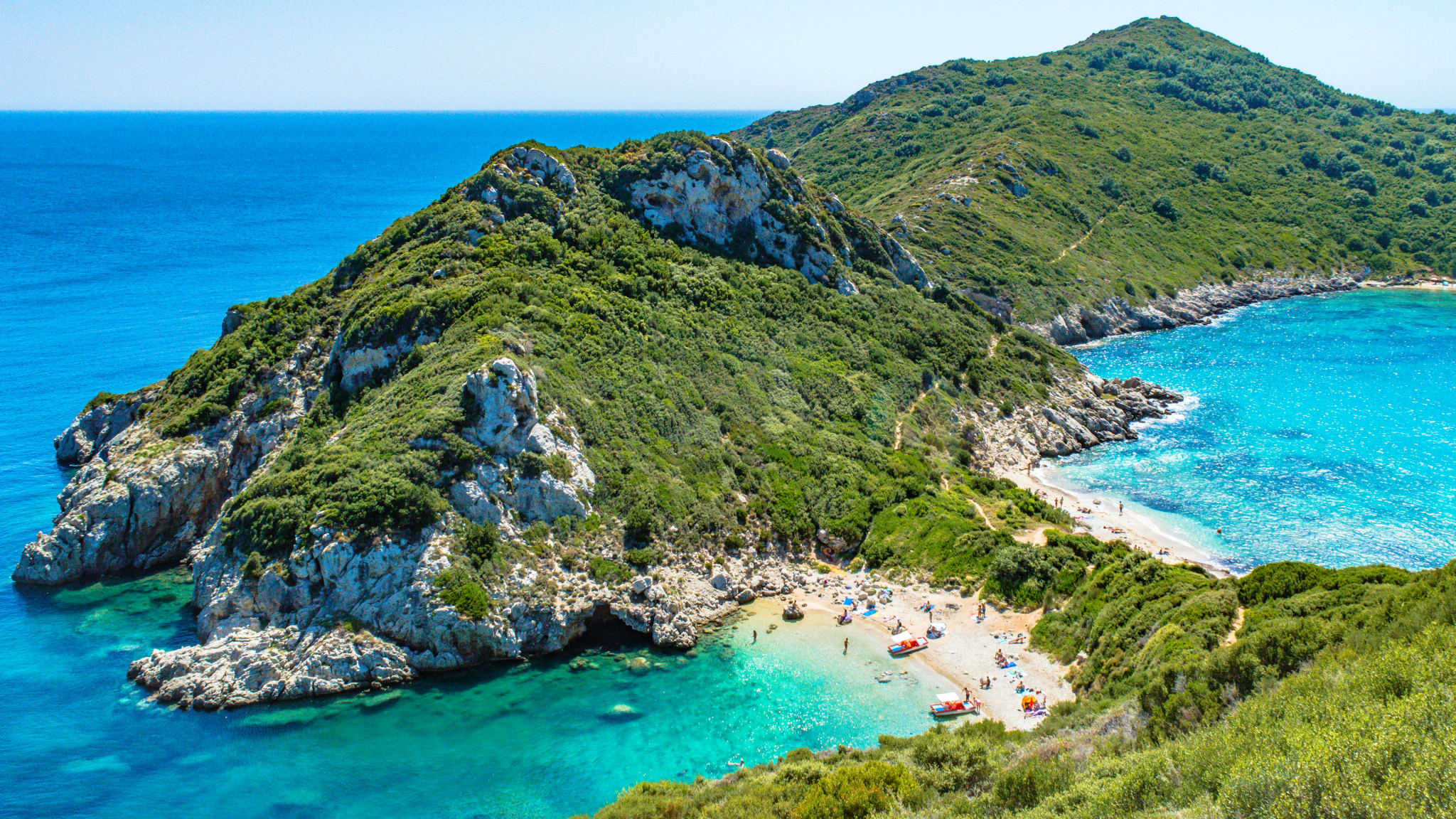 Two turquoise bays and green hills on the north-west coast of Corfu, seen from above