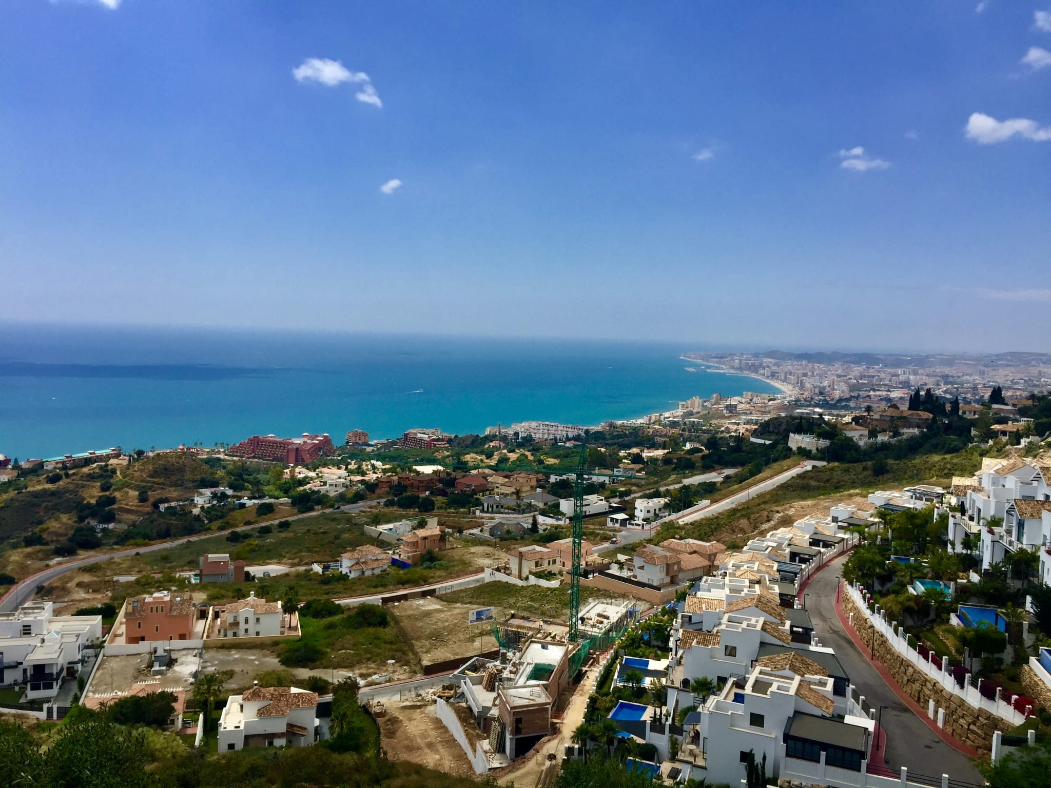 Benalmádena seen from above, with white buildings, green hills and the blue sea along the Costa del Sol