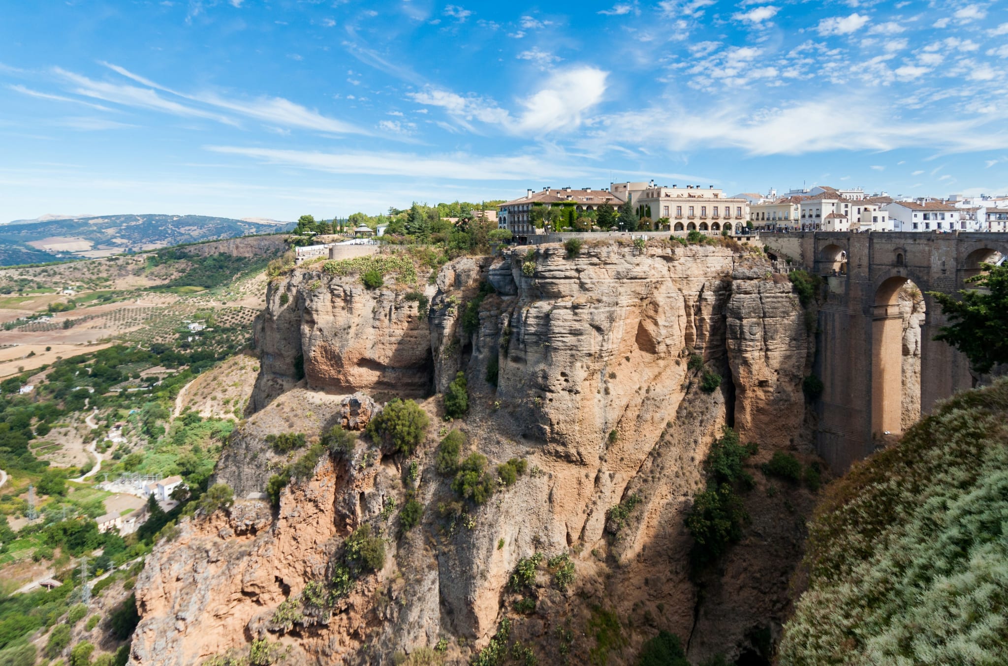 Ronda på klippen over juvet, med hvite hus helt ute på kanten og grønt landskap under