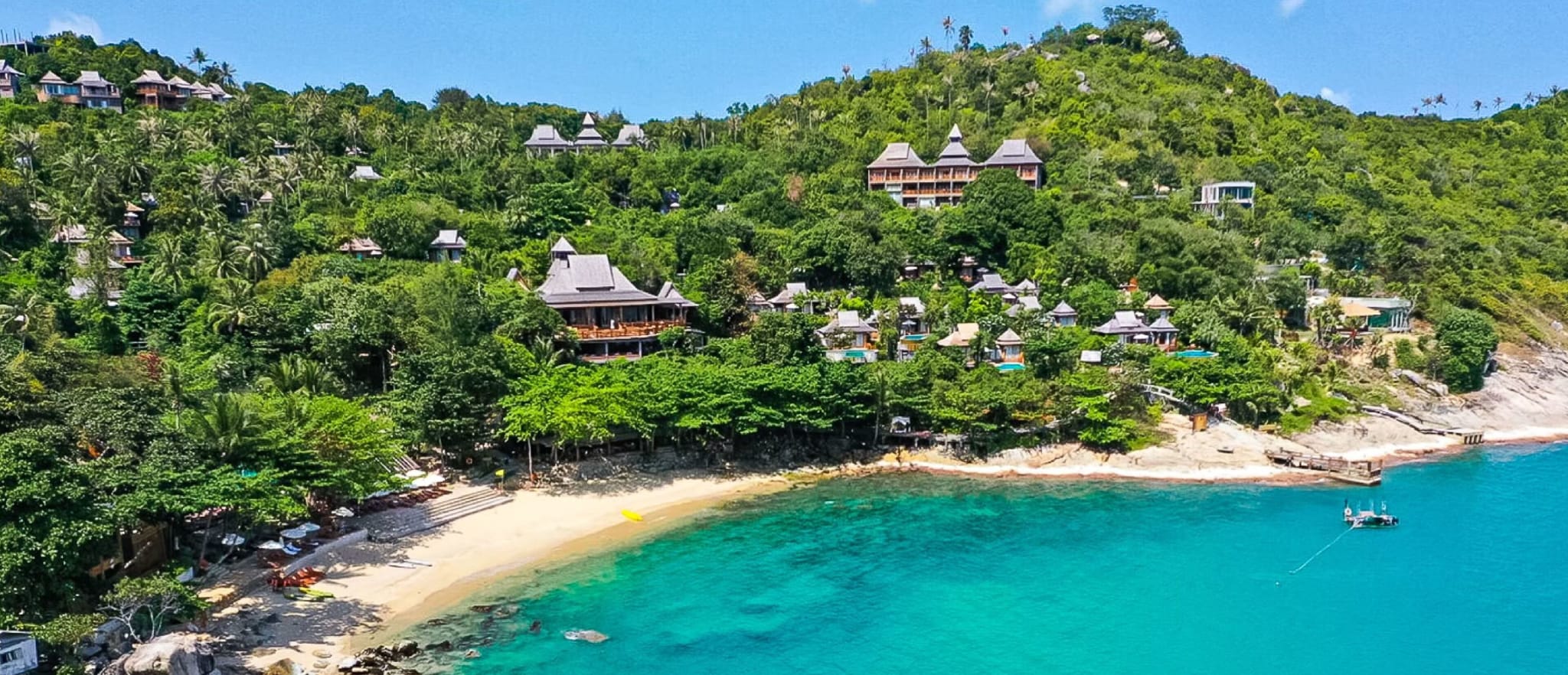Green jungle running down to a turquoise bay at Santhiya on Koh Phangan