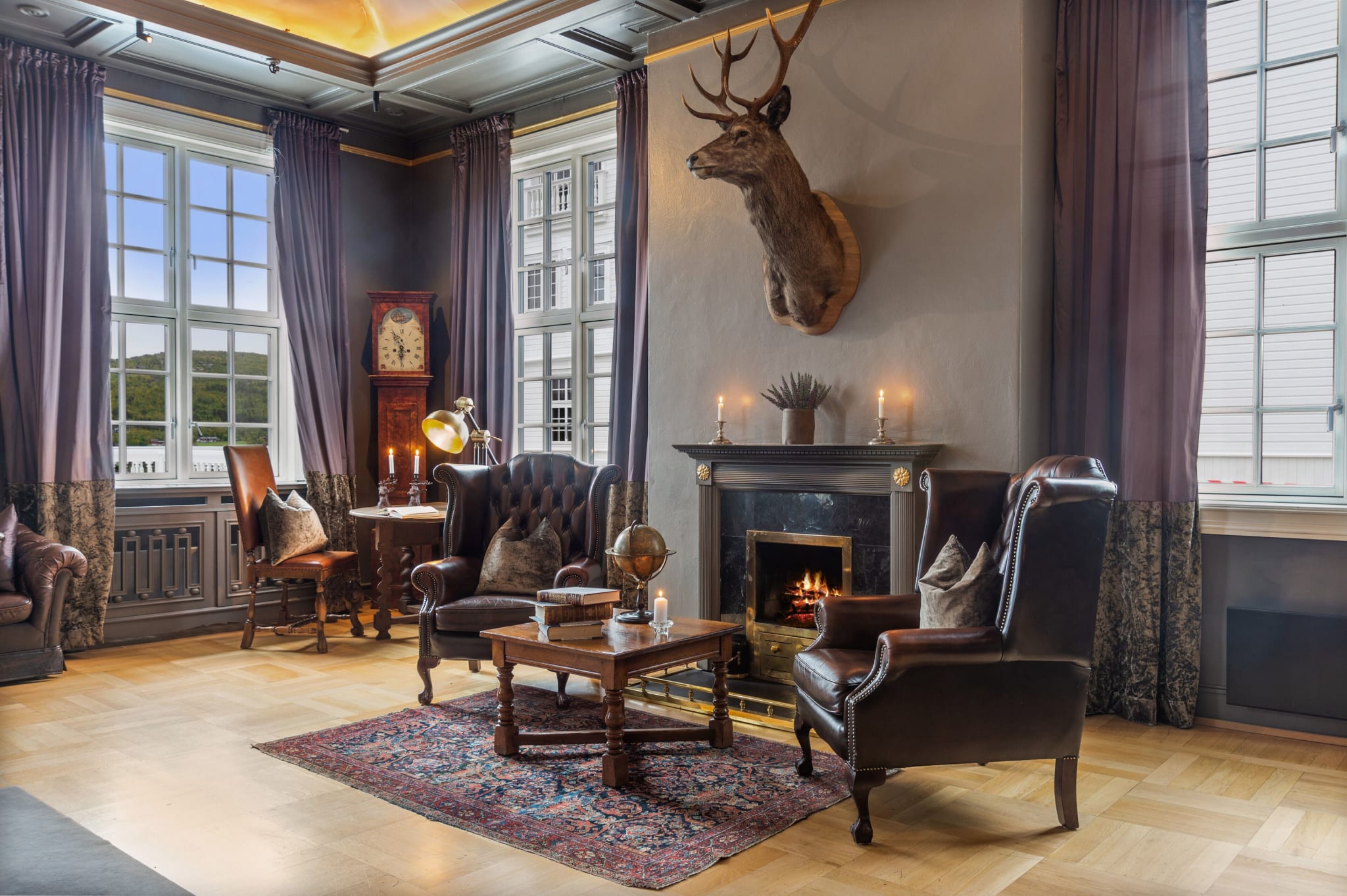 Lounge with fireplace and antlers at Dr. Holms Hotel in Geilo