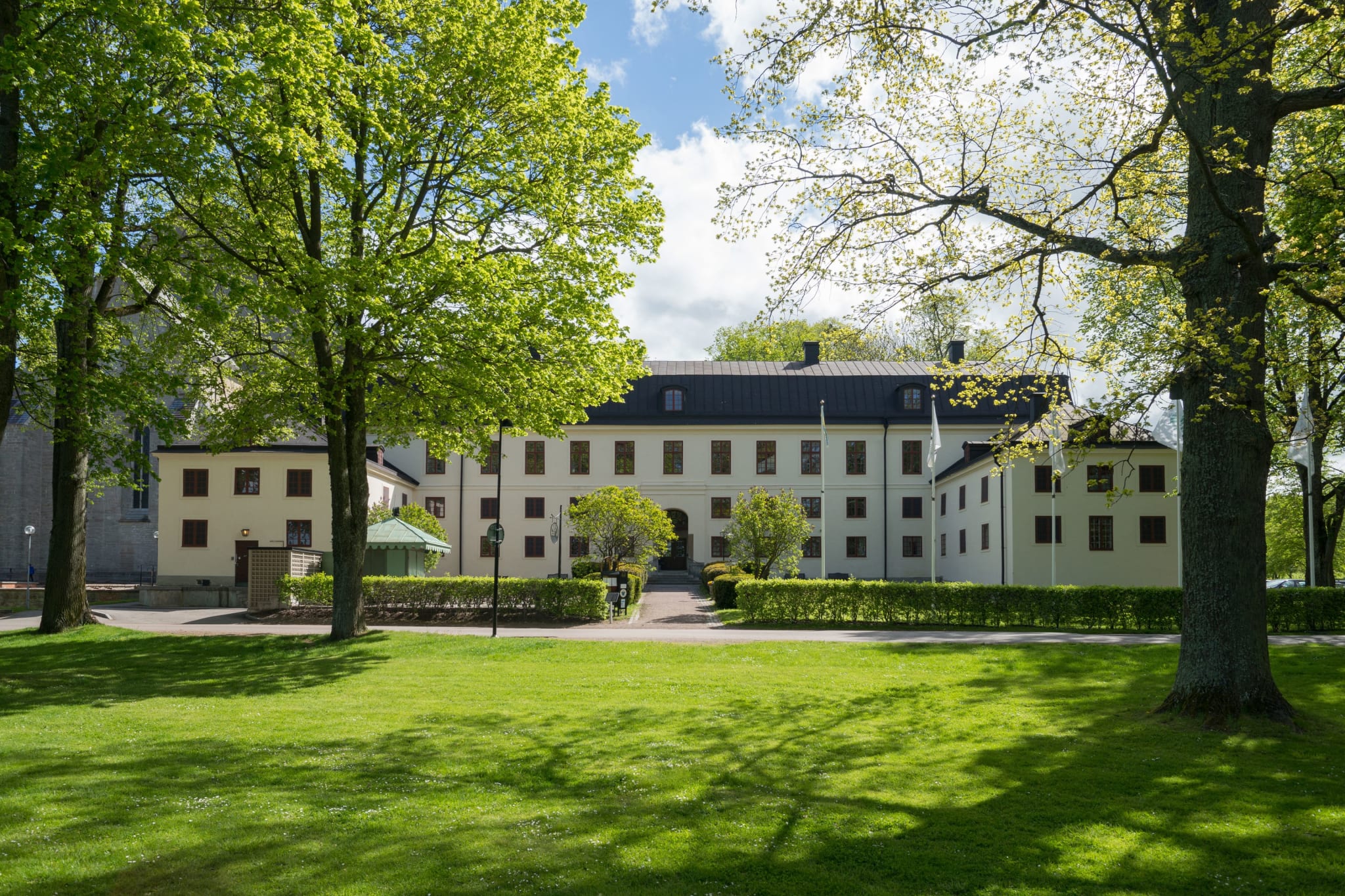 Vadstena Klosterhotel with a green lawn and old trees