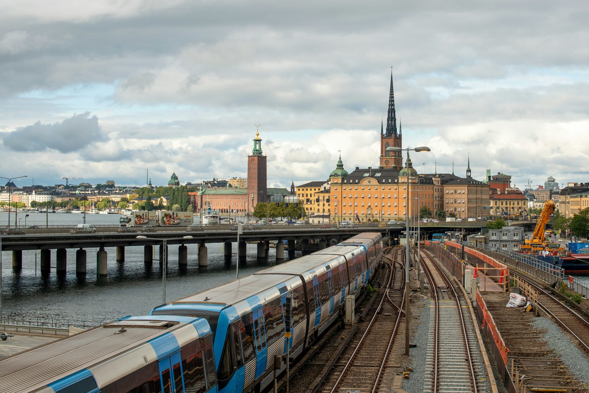 A train on the tracks into Stockholm, with Riddarholmen and the spires of Gamla stan across the water