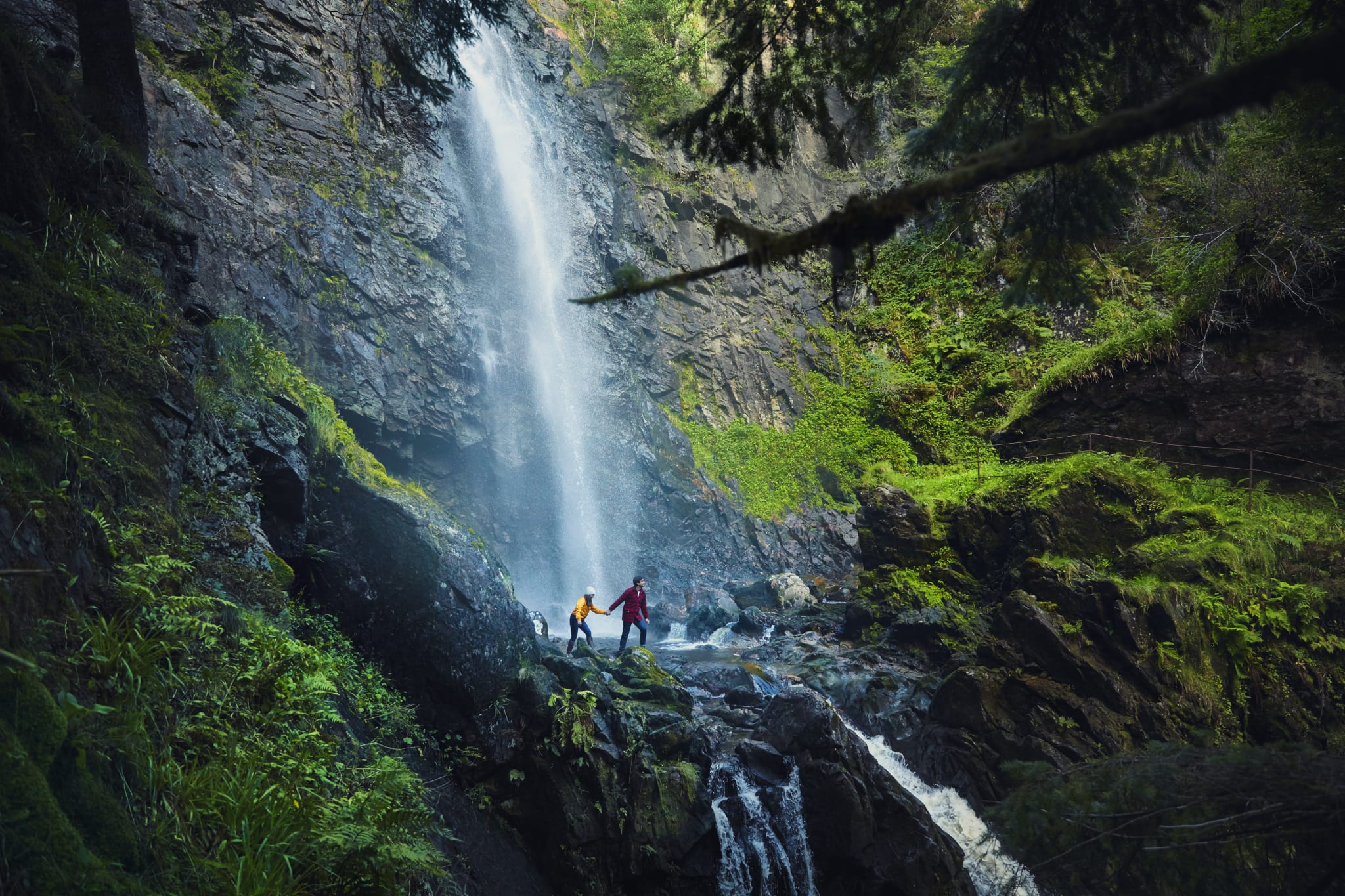 A couple by a waterfall in the Scottish Highlands