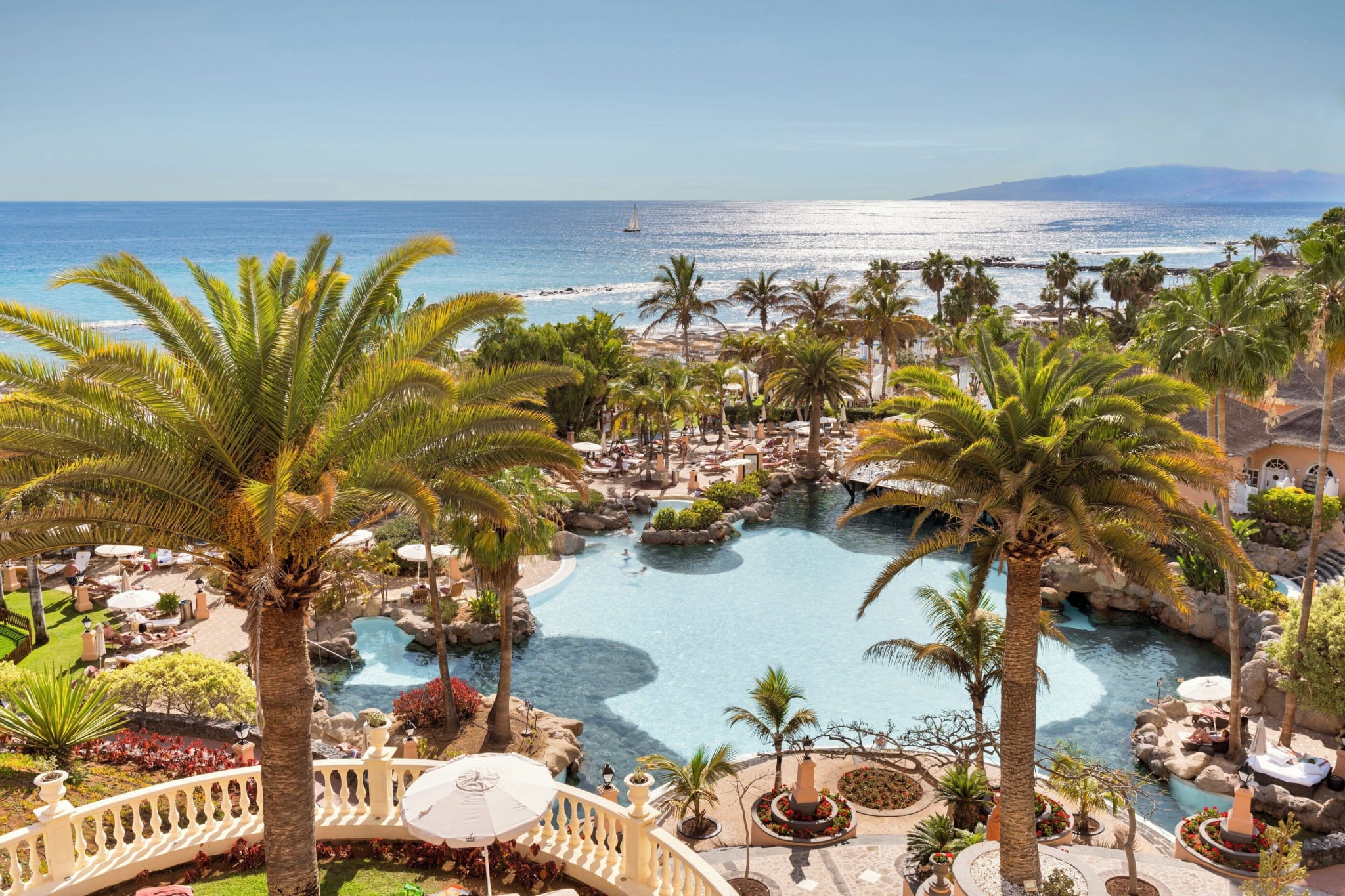 Gardens and pools at Bahía del Duque in Costa Adeje with the sea behind