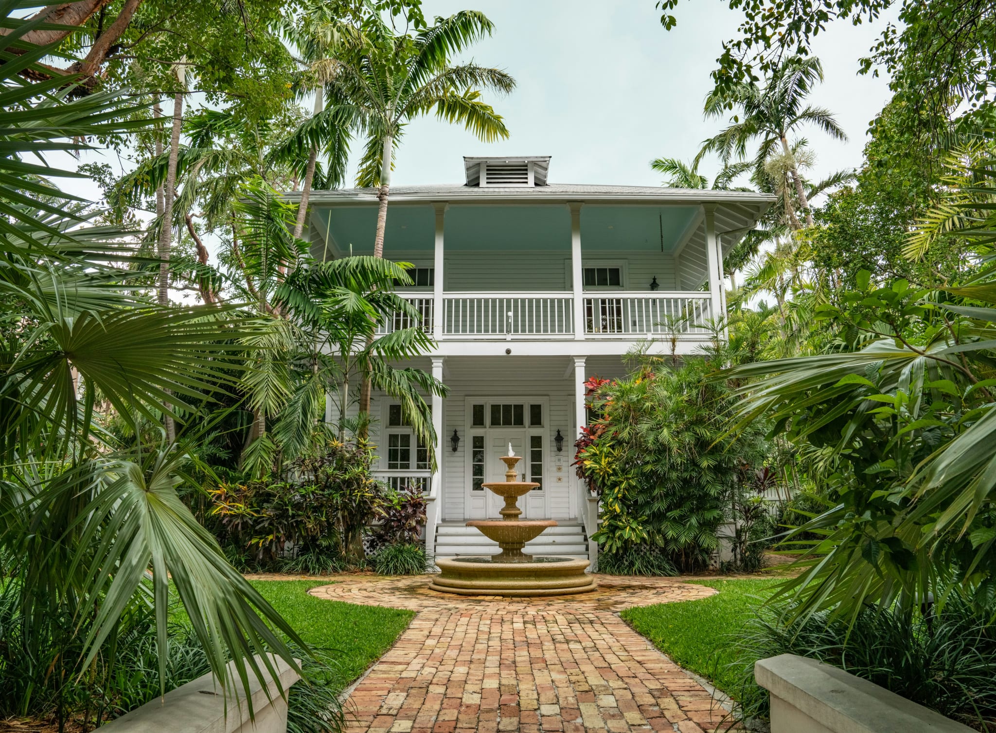 Hvitt trehus med veranda, fontene og palmer i Key West