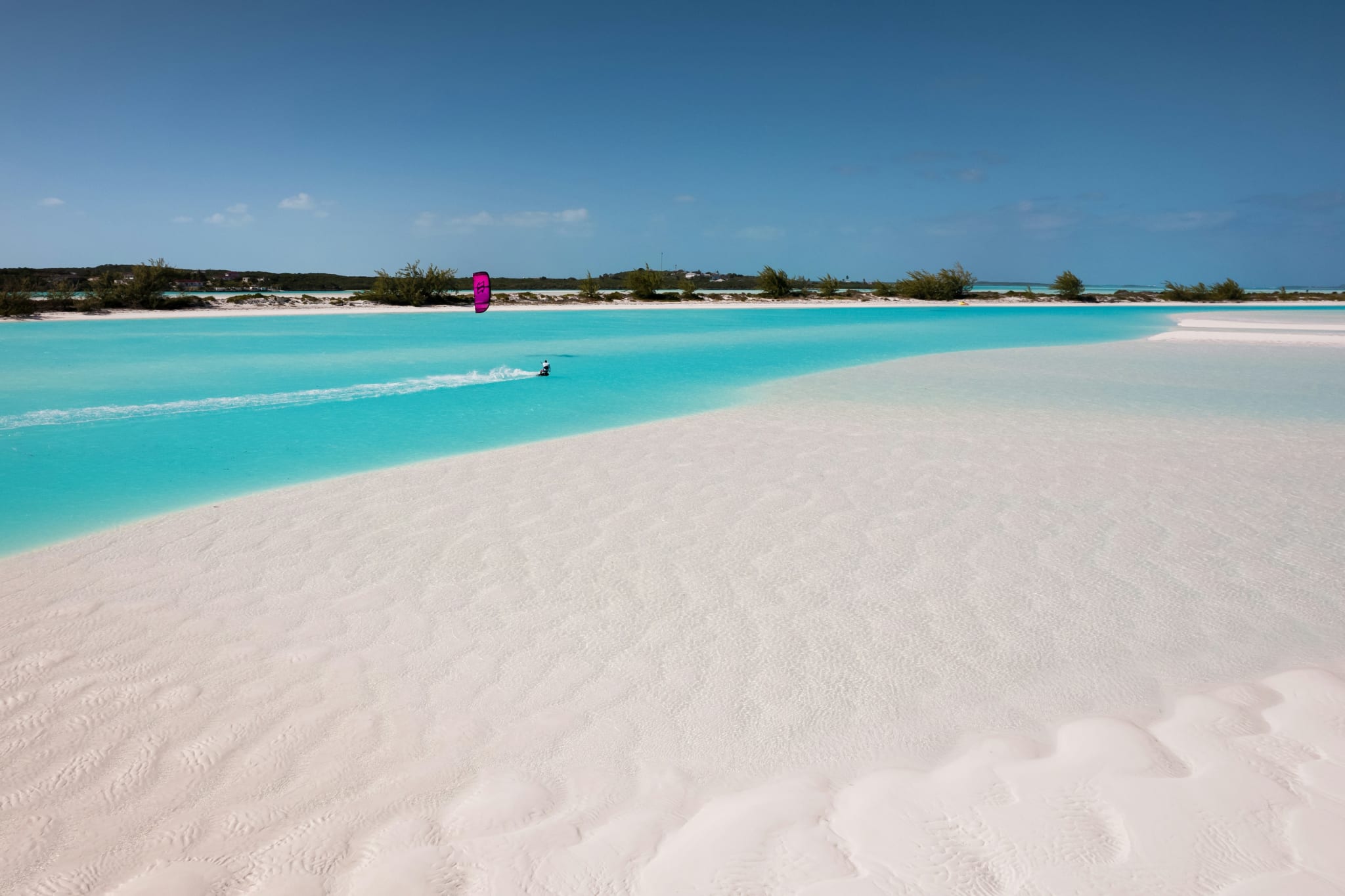 Grunt, turkis vann over en hvit sandbanke på Bahamas