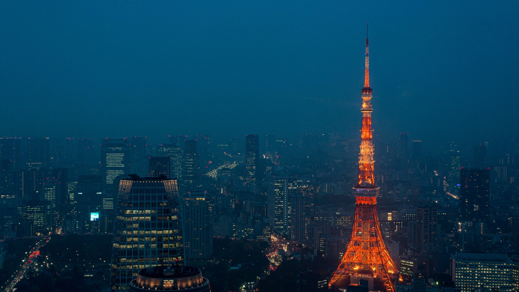 Tokyo Tower glowing orange above Minato at night