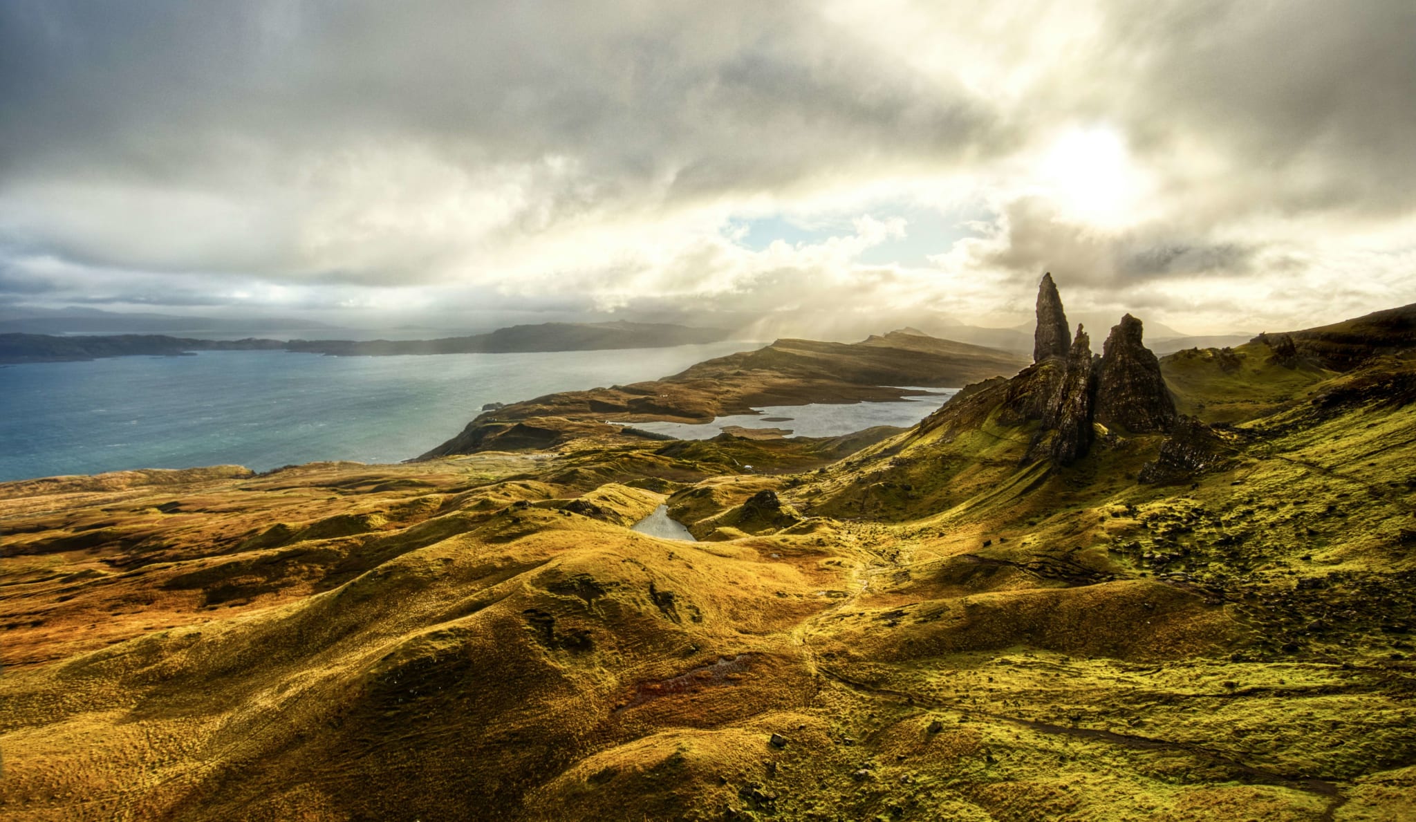 The rock pinnacles of the Old Man of Storr above green hills on the Isle of Skye