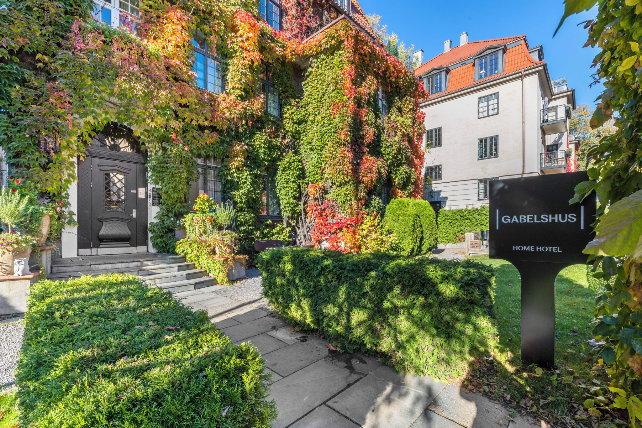 Inngangen til Home Hotel Gabelshus, dekket av eføy