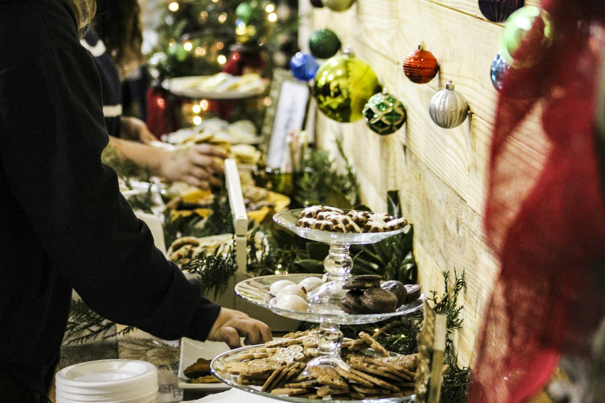 Pepperkaker og julemat på et julebord med julekuler på veggen