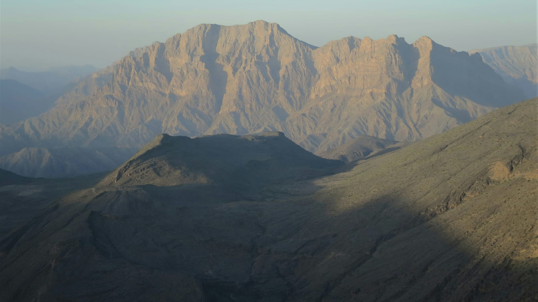 A deep canyon in the Hajar Mountains in Oman in low sunlight