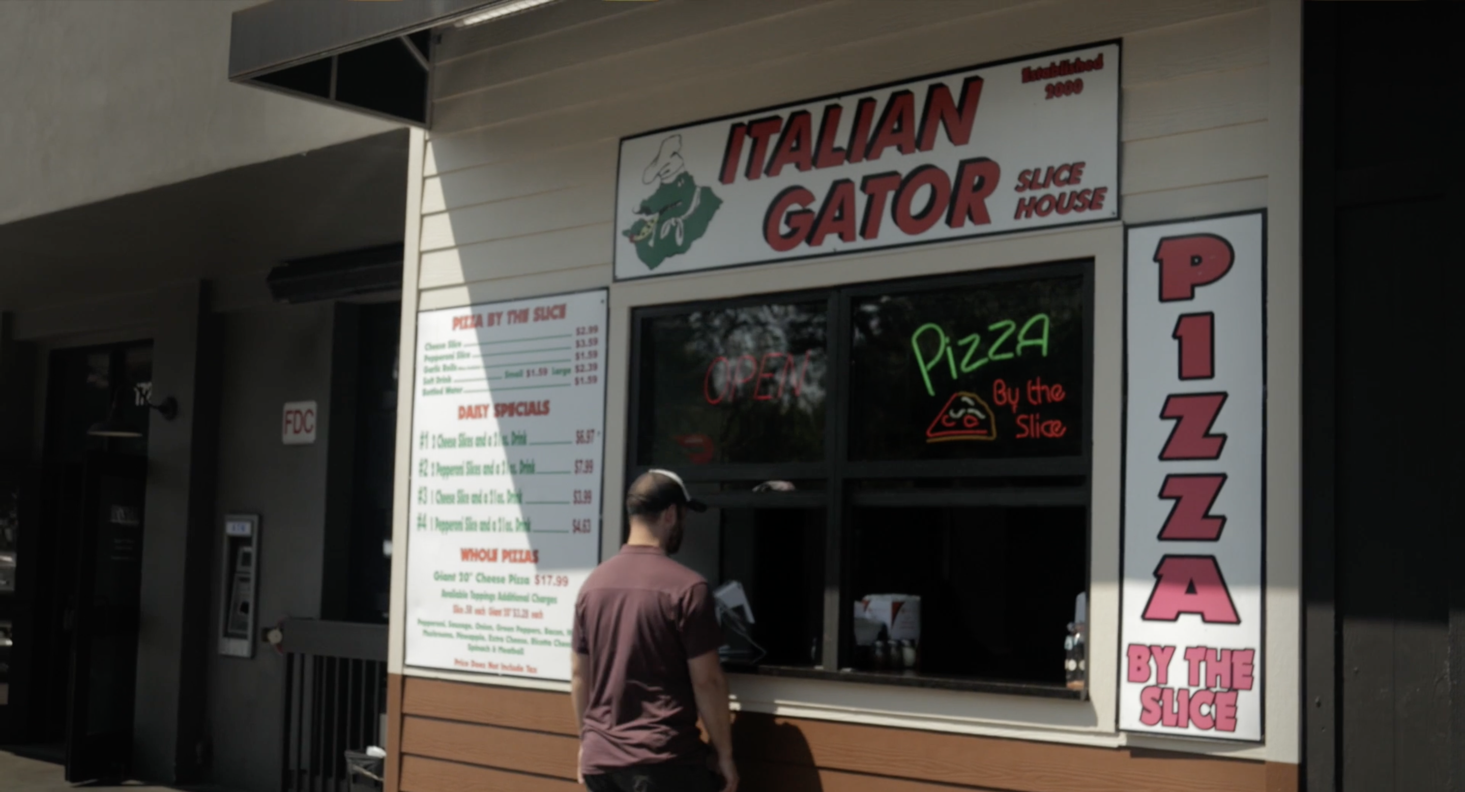 Person standing outside building with ITALIAN GATOR signage