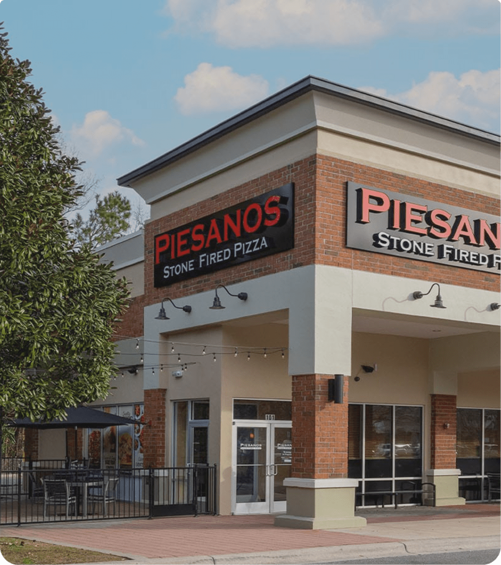Exterior building with Piesanos Stone Fired Pizza signage