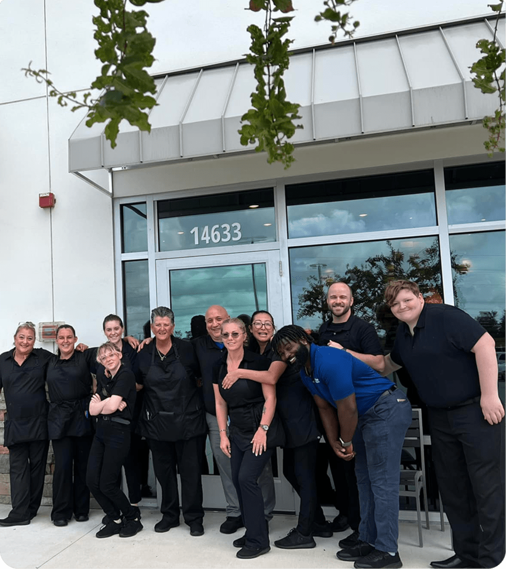 Eleven staff members standing outside Piesanos restaurant