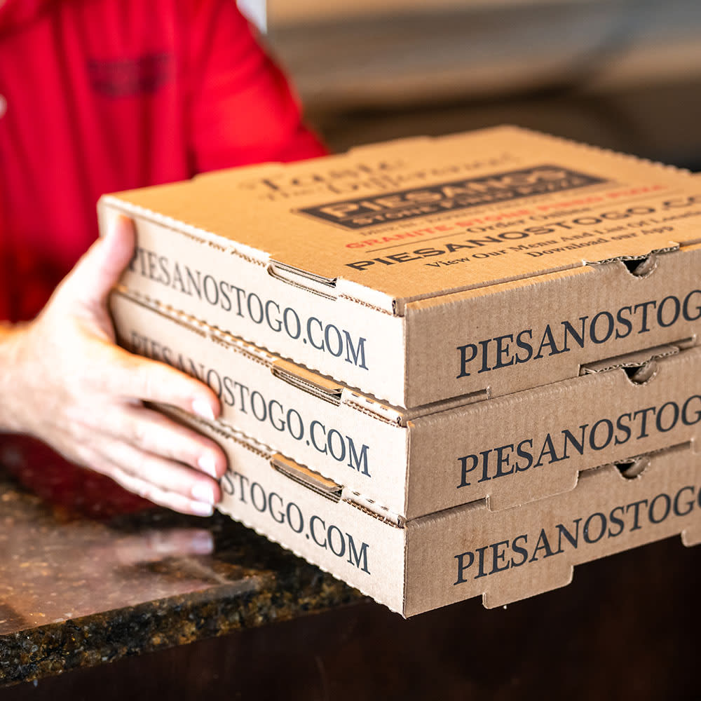 Hands holding three pizza boxes, showing the website PIESANOSTOGO.COM
