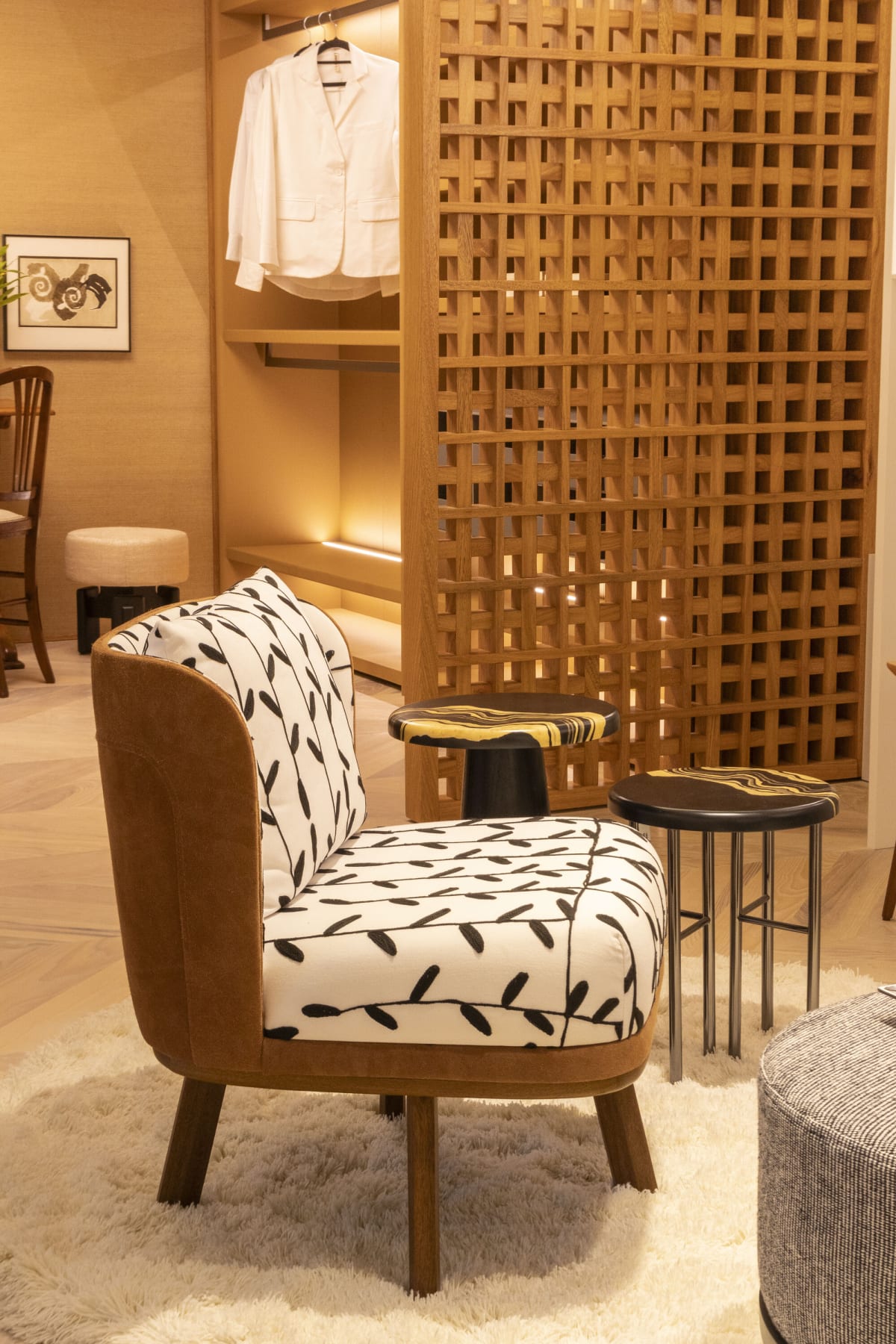 Leaf print armchair with walnut frame in front of an oak lattice screen