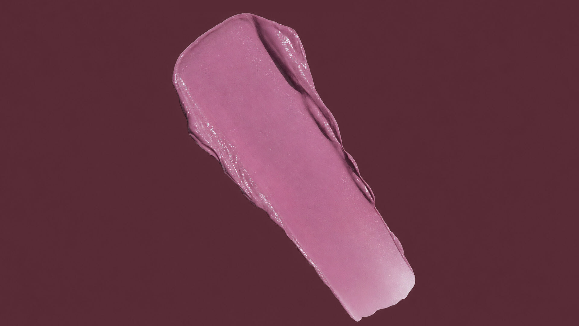 Matte plum lipstick smear swatched across a dark berry background