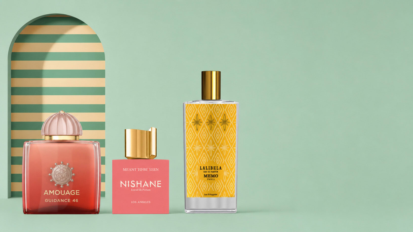 Amouage and Nishane fragrance bottles beside a gold perfume before a striped mint niche