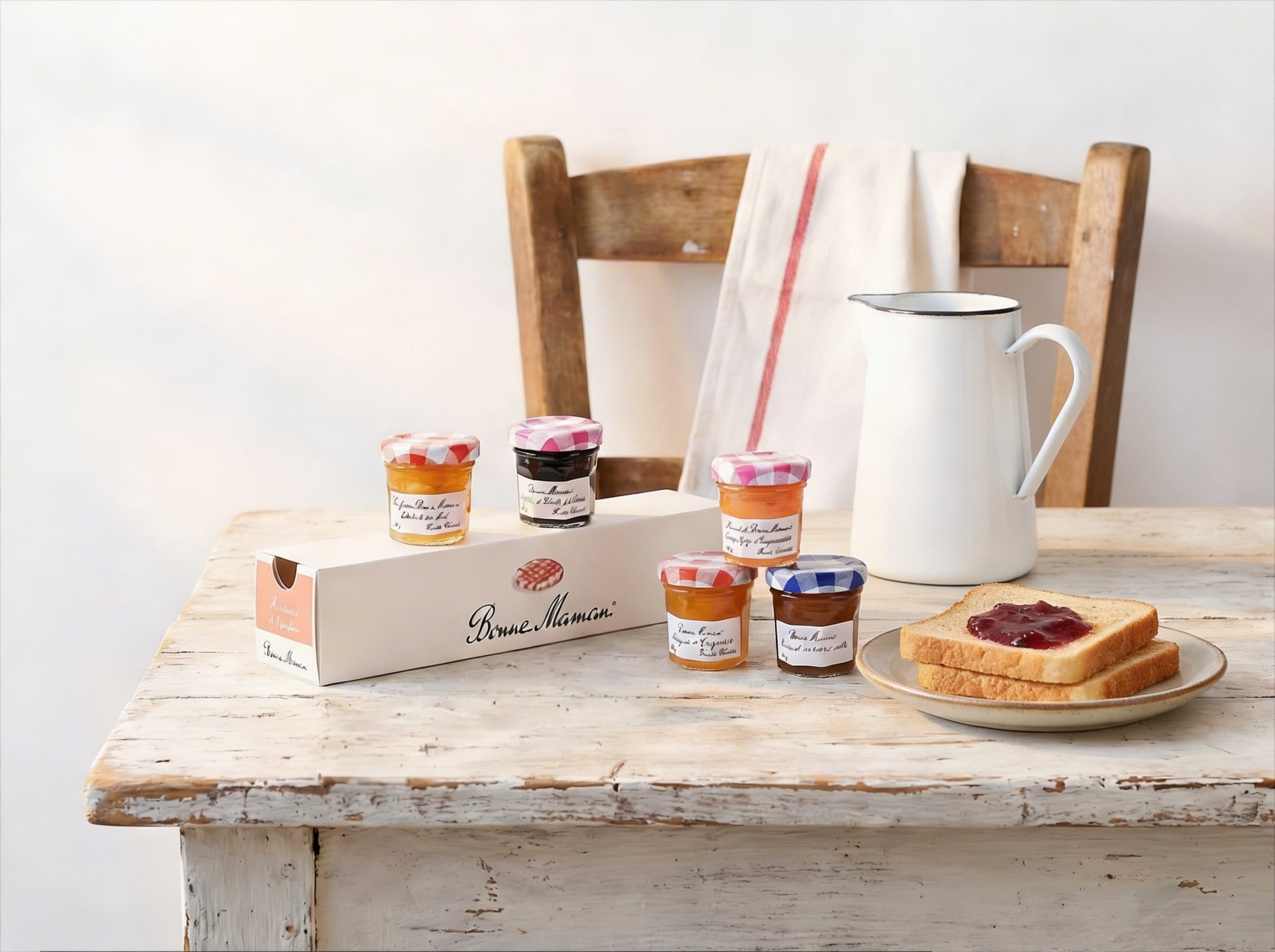 Bonne Maman mini jars and gift box with jam toast on a white painted wooden table