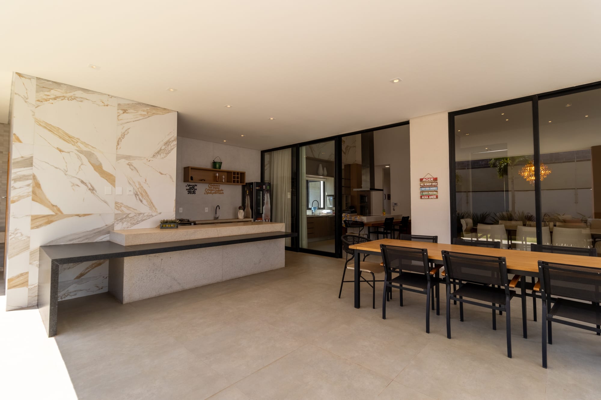 Gourmet area with marble veined wall, long table and glass doors