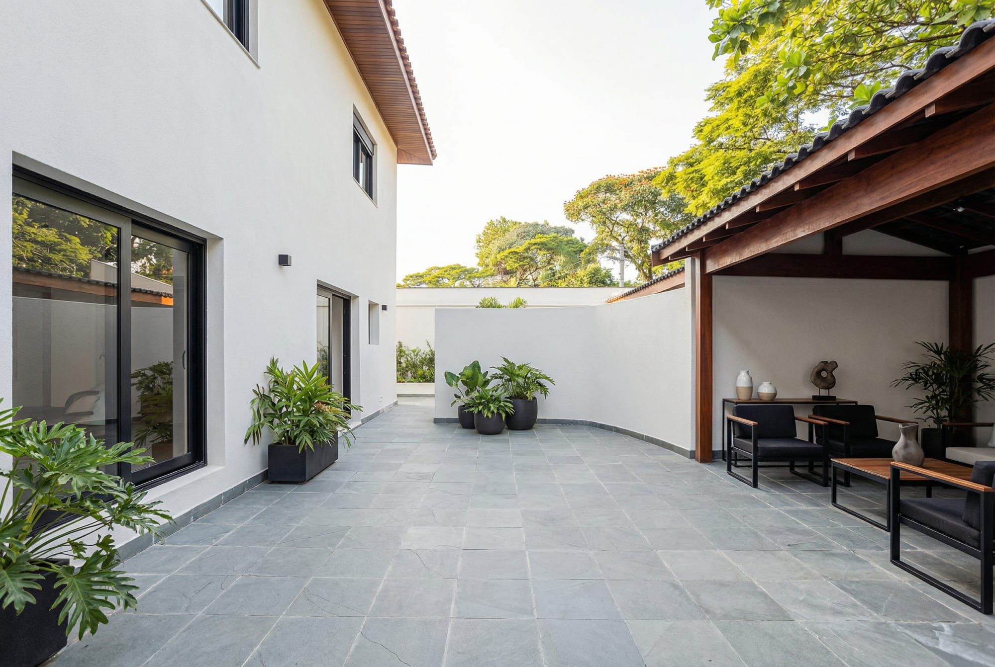 Slate courtyard with potted plants and a covered timber terrace