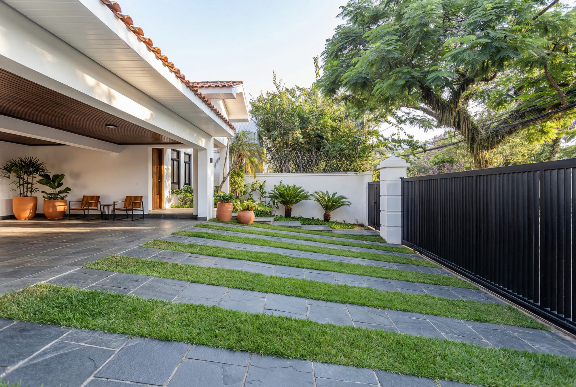 Side yard with slate and grass strip paving beside a covered porch