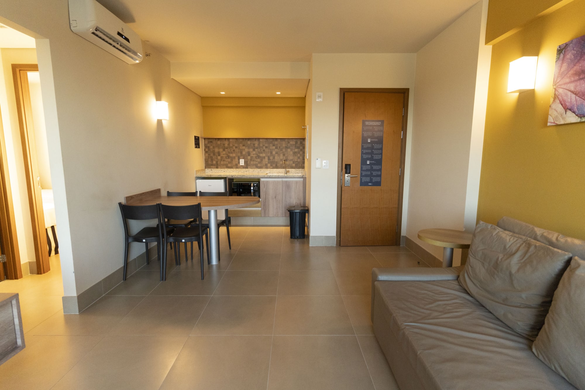 Apartment living room with leather sofa, dining table and kitchenette