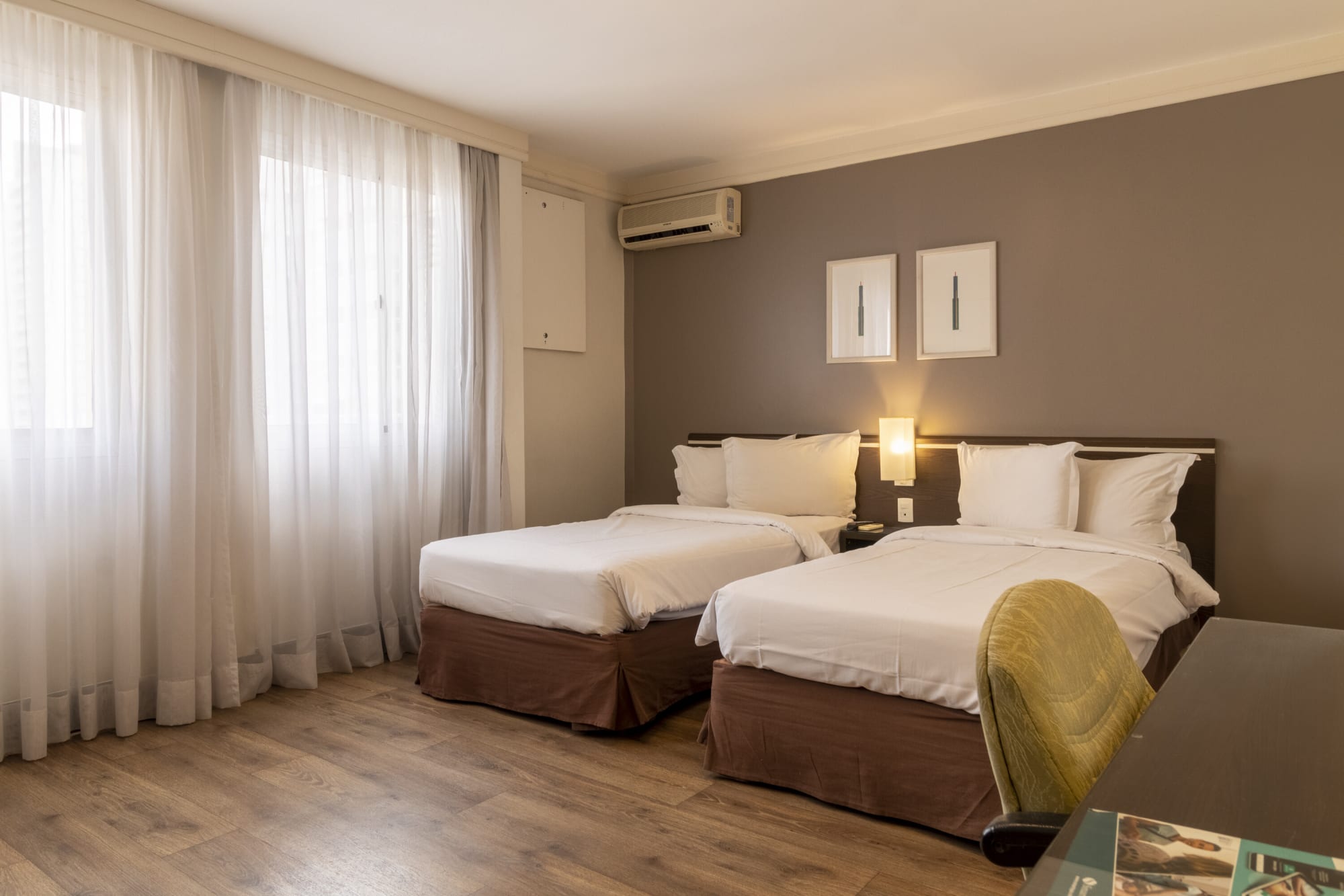 Twin room with two beds, brown skirts and a green desk chair