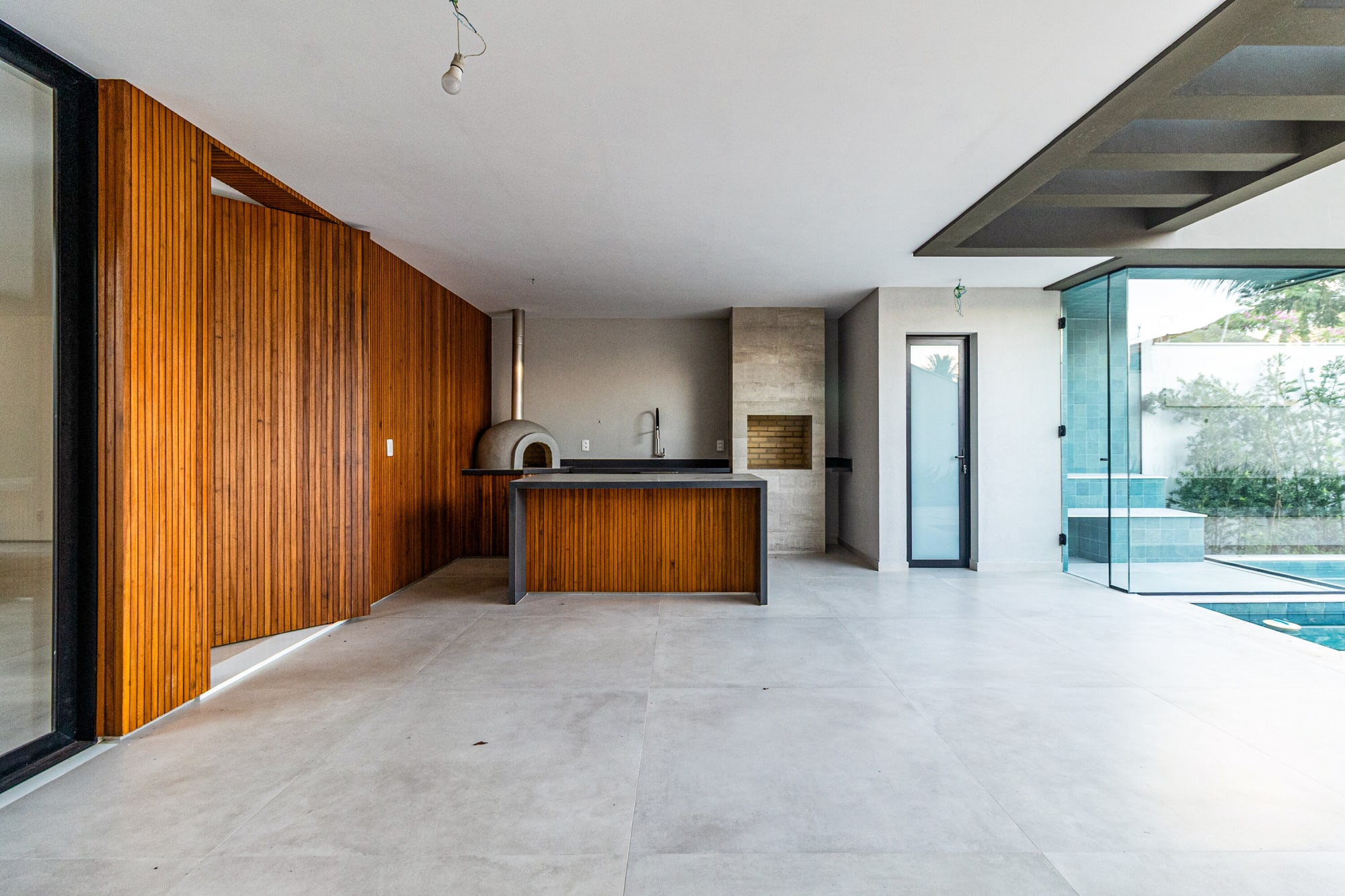 Empty gourmet area with slatted timber wall, pizza oven and dark counter