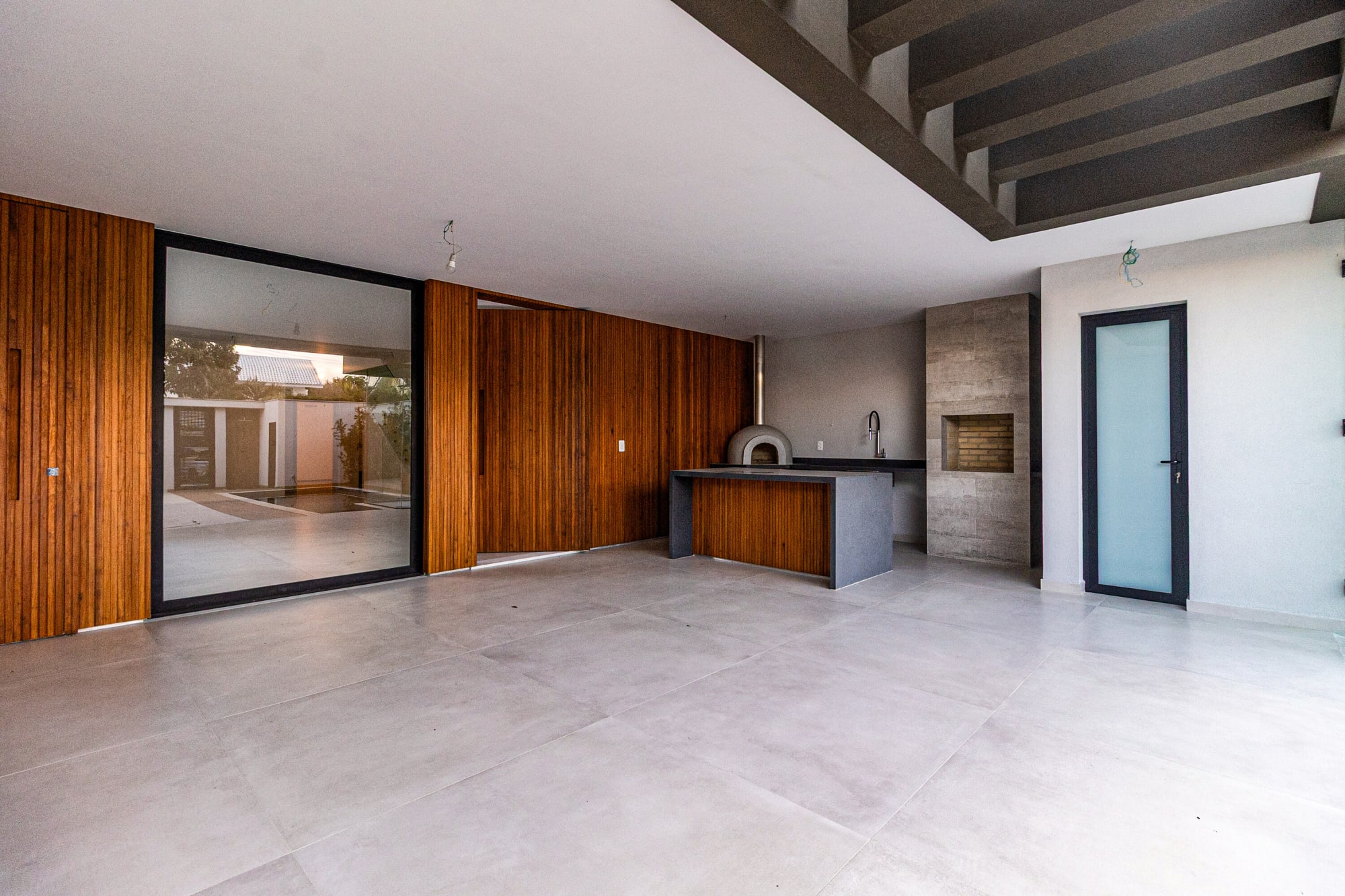 Unfurnished living area with sliding glass door and timber panelled wall