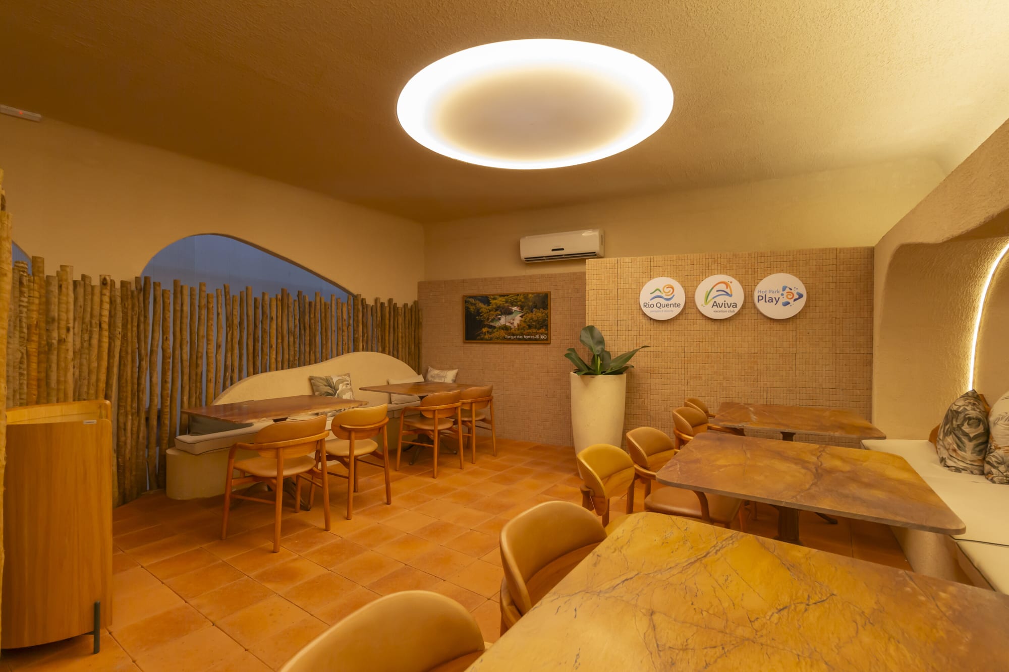 Dining corner with stone topped tables, timber chairs and decorative plates on a plaster wall