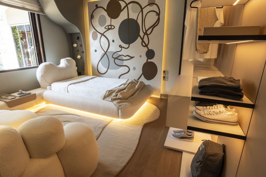 Teen bedroom at CASACOR Curitiba with a lit floating bed, line drawn mural and open closet