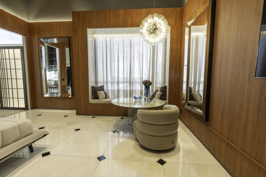 Natuzzi suite at CASACOR Goiania with walnut panelling, round table and sheer curtains