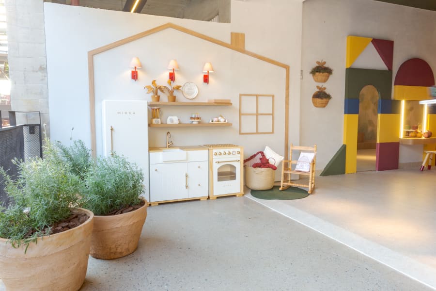 Playroom at CASACOR Minas with a house shaped wall, toy kitchen and potted rosemary