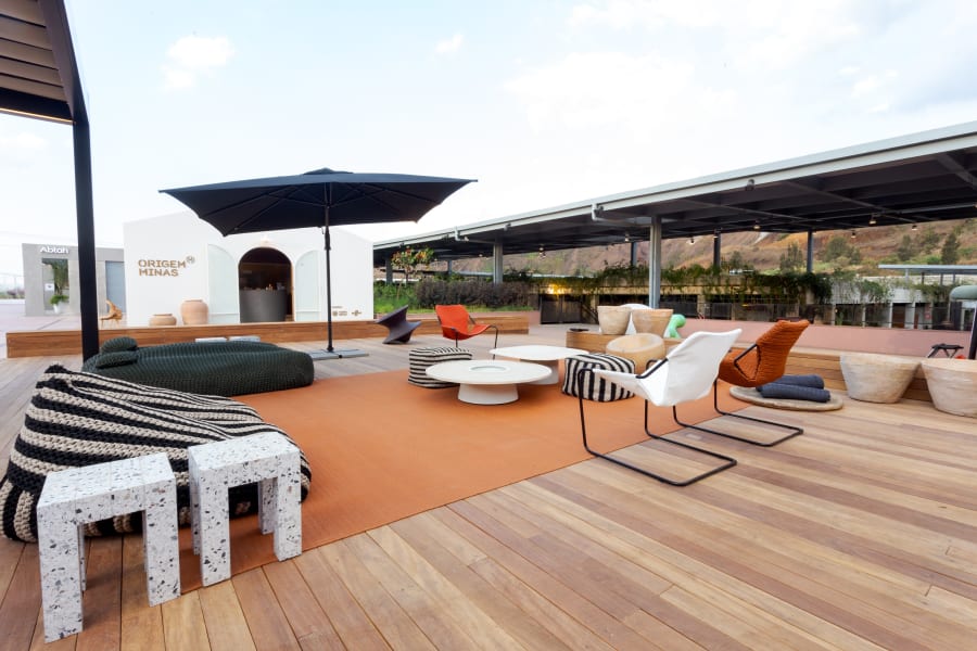 Rooftop terrace with striped outdoor sofa, orange rug and black parasol beside a pavilion