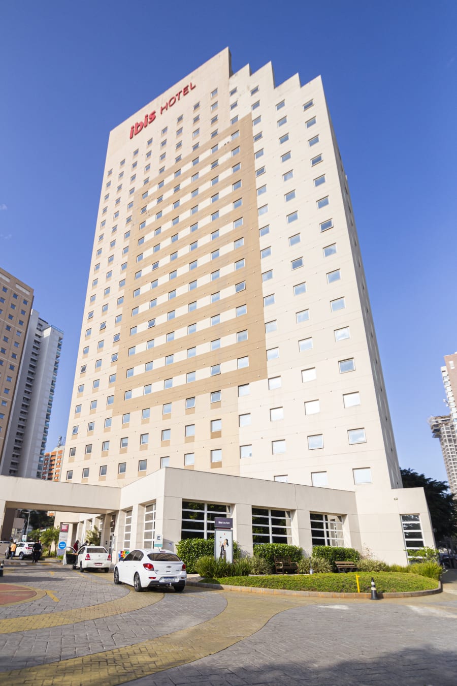 ibis Morumbi hotel tower with red logo above the entrance under a blue sky