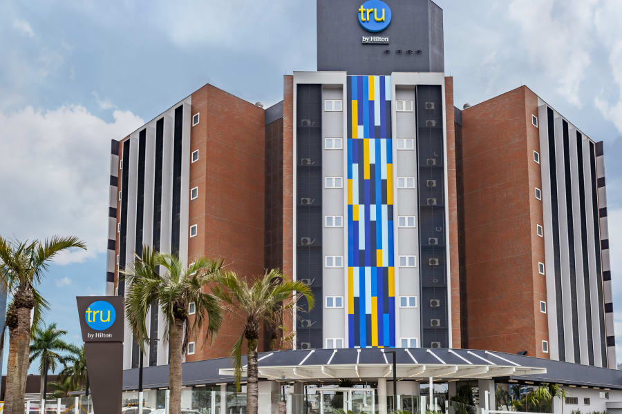 Tru by Hilton Criciúma brick facade with blue and yellow colour block stripe and palms