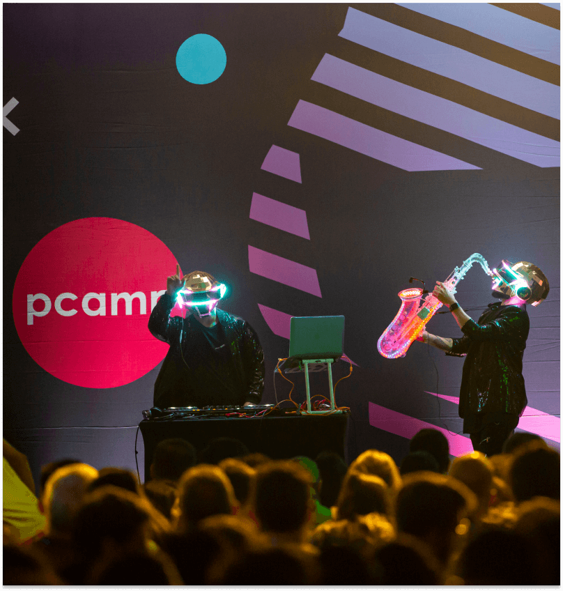 Two man on stage making music at an event