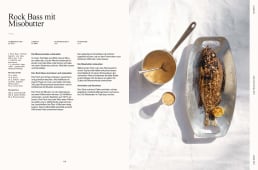 Gegrillter ganzer Fisch auf einer Metallplatte mit Limette, daneben ein Topf Misobutter und eine kleine Schale Sauce.