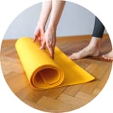 Frau rollt Yogamatte aus