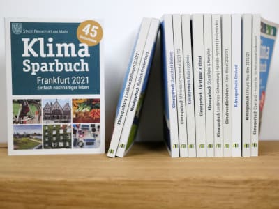 Klimasparbücher auf Regalbrett, Klimasparbuch Frankfurt 2021 Cover zu sehen